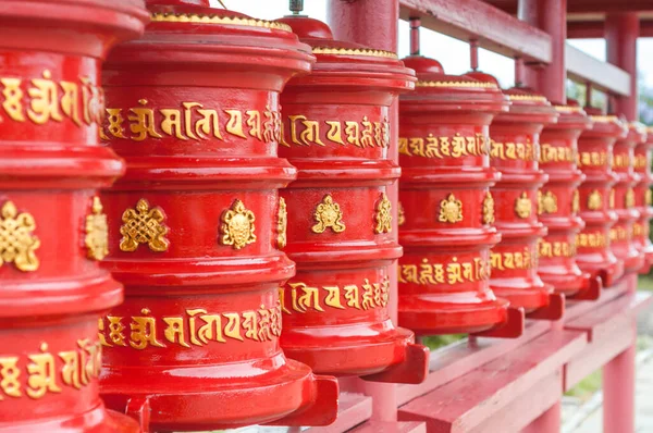 The prayer wheels in a row. Religious symbol of buddhism