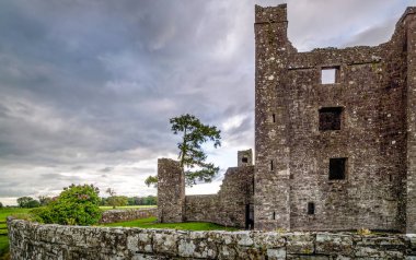 Gün batımında dramatik gökyüzü ile Bective Abbey harabeleri. İrlanda