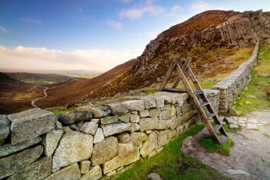 Mourn Wall with ladder on the Hares Gap overseeing beautiful valley with blue sky and white clouds