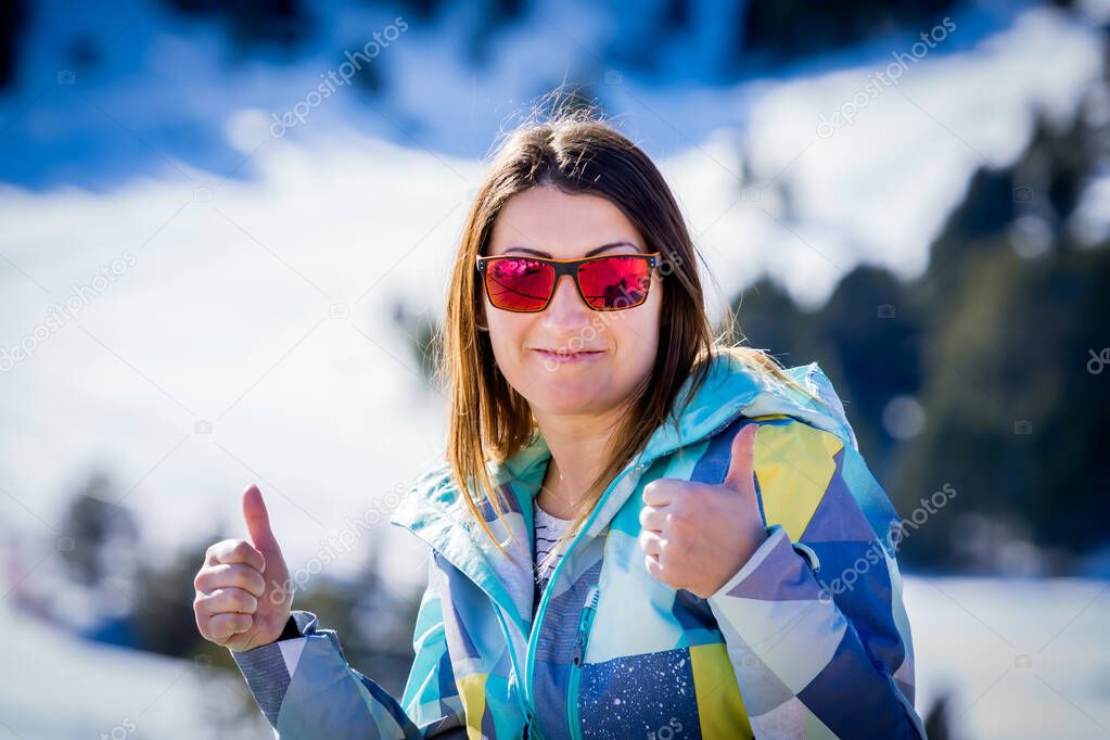 Portrait of Caucasian white woman, skier showing thumbs up with winter background. Winter holidays in El Tarter, Grandvalira, Andorra