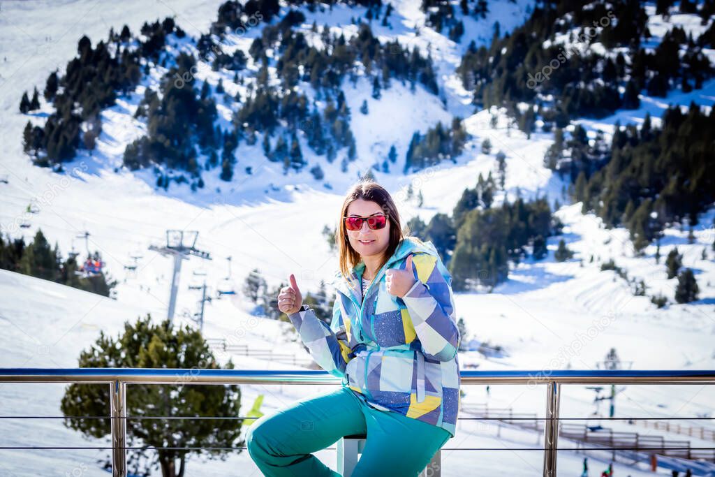 Portrait of Caucasian white woman, skier showing thumbs up with winter background. Winter holidays in El Tarter, Grandvalira, Andorra