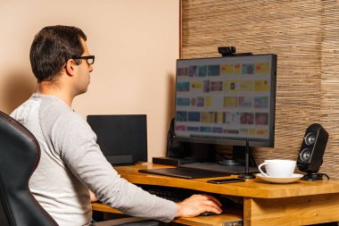 Orta yaşlı bir adam covid 19 ya da koronavirüs salgınları sırasında evindeki konfordan bilgisayarla çalışıyor. Tecrit ve karantina.