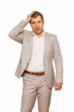 Beyaz arka planda izole edilmiş, Coronavirüs durgunluğu sırasında işi düşerken bej süitteki orta yaşlı işadamı depresyonda ve şokta.