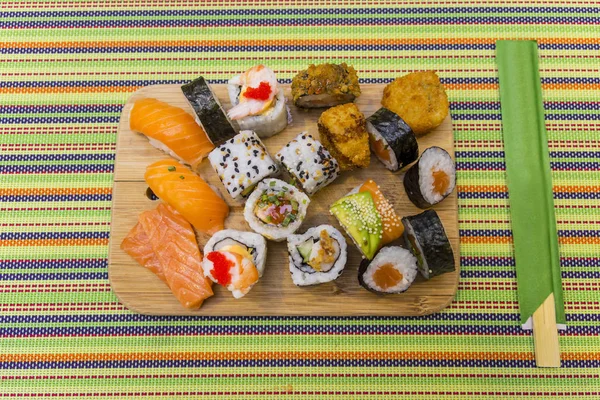 Tablero de madera con sushi surtido — Foto de Stock