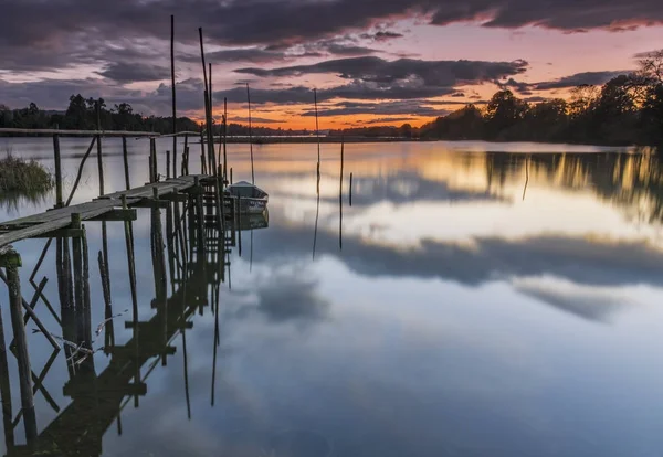 Pôr do sol no rio perto de um barco — Fotografia de Stock