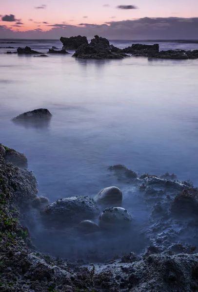 Beach with blue water at sunset — Stock Photo, Image