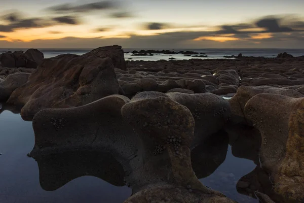 Strand mit Felsen bei Sonnenuntergang — Stockfoto