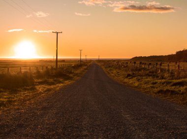 Sonsuz yol gün batımında ufukta kayboluyor.