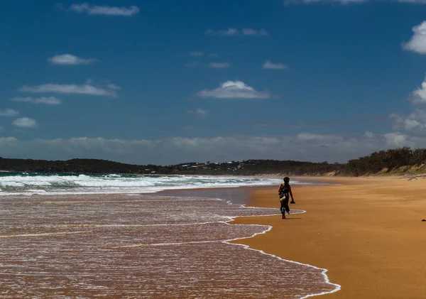 Mulher solitária andando em uma praia vazia — Fotografia de Stock