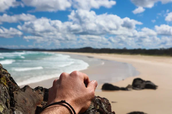 Mão de homem com uma praia longa e vazia no fundo — Fotografia de Stock