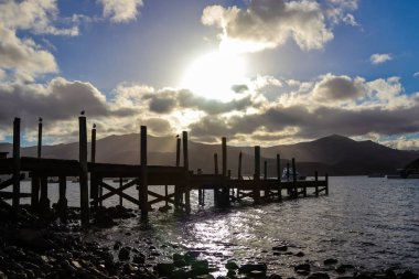 Gün batımında ahşap bir iskelenin silueti