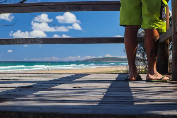 Pernas do homem agains a praia no fundo — Fotografia de Stock