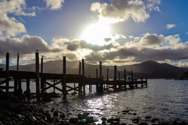 Gün batımında ahşap bir iskelenin silueti