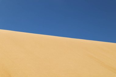 Açık mavi gökyüzüne karşı kumdan yapılmış bir çizgi.