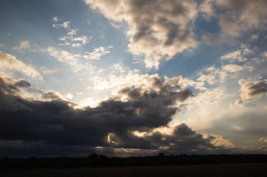 Bulutlar gün batımında bulutların arasından geçen güneş ışınlarıyla