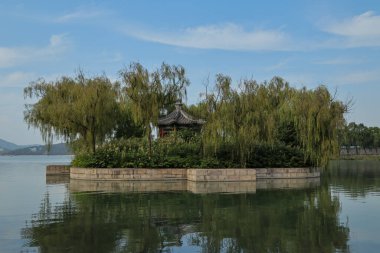 Ağaçları ve gölün ortasında kulübesi olan küçük bir ada.