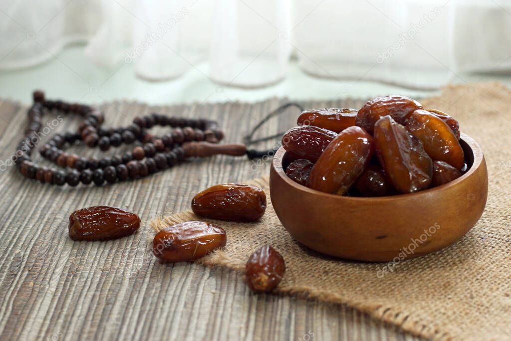dates fruit and prayer beads on table top                               