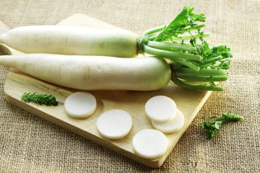        Kesme tahtasında servis edilen taze beyaz turp ya da daikon turpu.                      