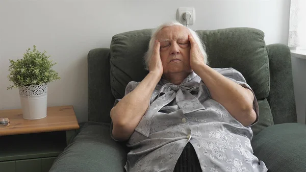 Starsza kobieta ma ból głowy.. — Zdjęcie stockowe