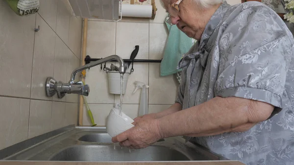 Seniorin spült Geschirr — Stockfoto