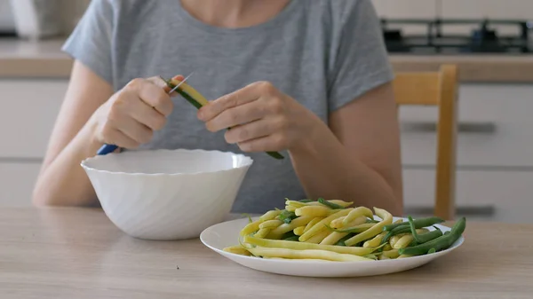 Vrouw bereidt gezonde maaltijd met groene en gele bonen. — Stockfoto