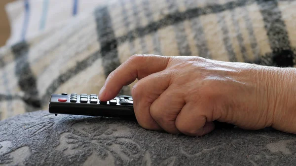 Рука пожилой женщины держит пульт от телевизора — стоковое фото