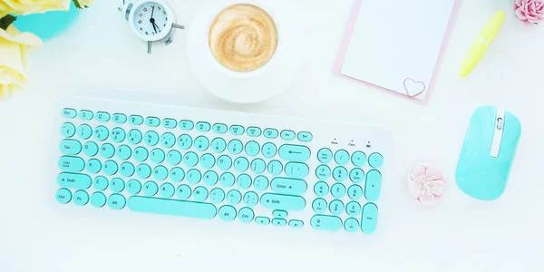Bilgisayar klavyesi ve faresi beyaz ve turkuazdır, bir pano, bir fincan kahve, bir çalar saat ve çiçektir. Merkez ofis konsepti. Sancak, düz düzen, üst görünüm