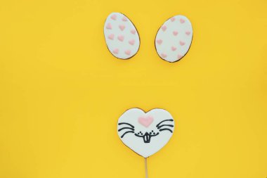 Renkli tavşan suratlı bir kalp şeklinde zencefilli çörek ve sarı zemin üzerinde pembe kalpler olan beyaz şeklinde zencefilli ekmek yumurtaları. Paskalya tavşanı kavramı