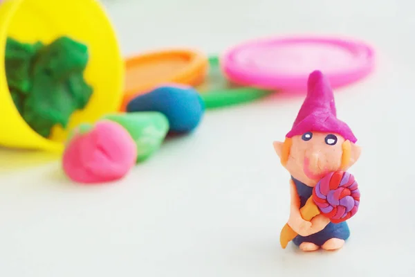 塑料侏儒形象与棒棒糖和粉红色的帽子 五颜六色的塑料 盖子和罐子后面 — 图库照片