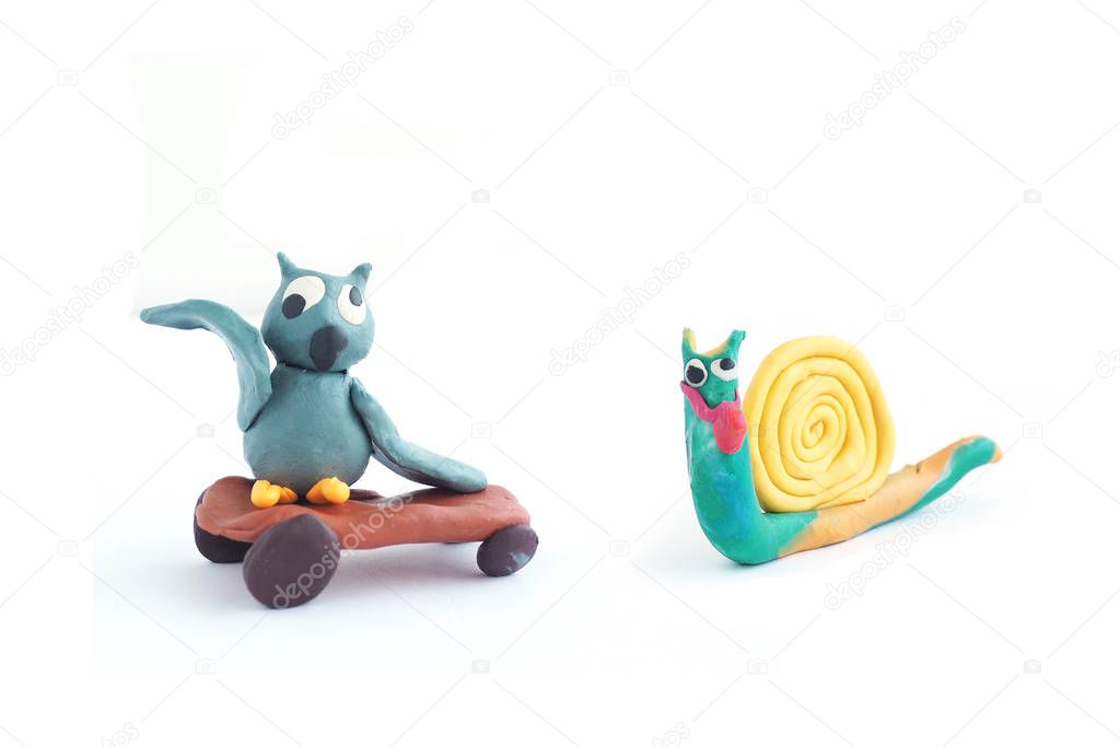 Cartoon plasticine figure owl on a skateboard and a plasticine snail. Isolate on a white background