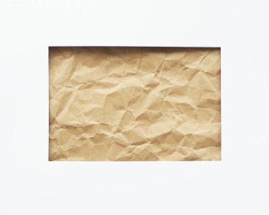 Beyaz bir kağıt parçasında dikdörtgen şeklinde bir delik. Arka planda buruşmuş el işi kağıtları var. Kopyalamak için boşluk