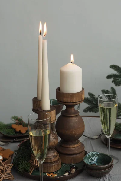 Τρία Αναμμένα Κεριά Ένα Τραπέζι Ξύλινα Κηροπήγια Δύο Ποτήρια Σαμπάνια — Φωτογραφία Αρχείου