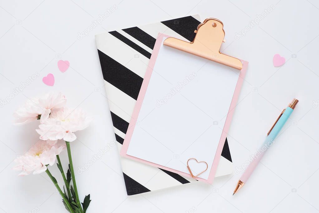 pink clipboard, black and white striped notebook, pink chrysanthemum flower, black polka dot pen and plastic hearts