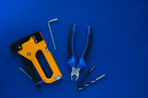 Schwarz Gelber Bauklammer Zange Bohrmaschine Möbelschlüssel Und Schrauben Auf Blauem — Stockfoto