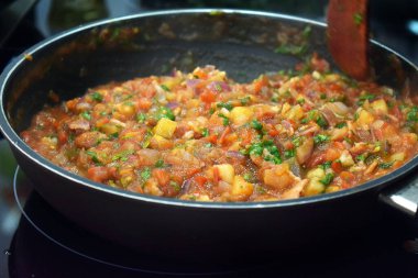 Tavada sebze sosu pişirmek.