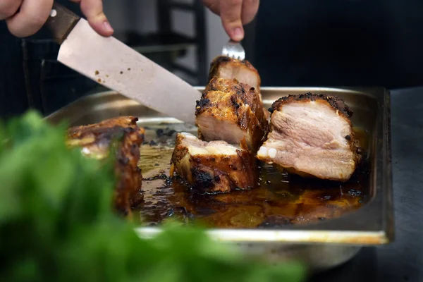 Cozinheiro corta carne com uma faca — Fotografia de Stock