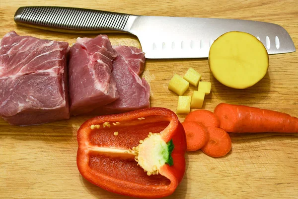 wooden cutting board with meat, vegetables and herbs. cooked knife for cooking