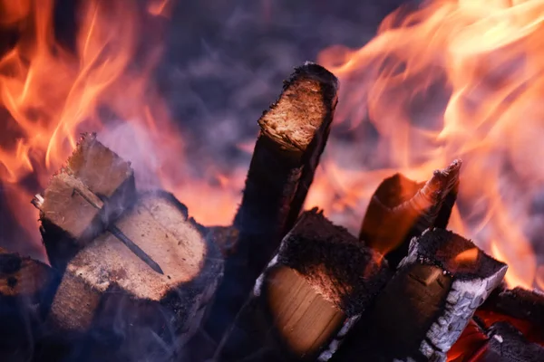 firewood burns in a red flame during a fire.