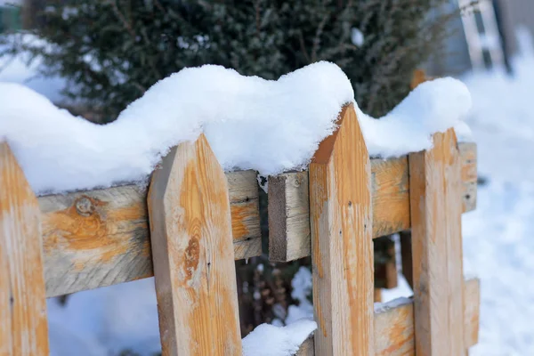 Snow lies on an old wooden fence. Royalty Free Stock Images