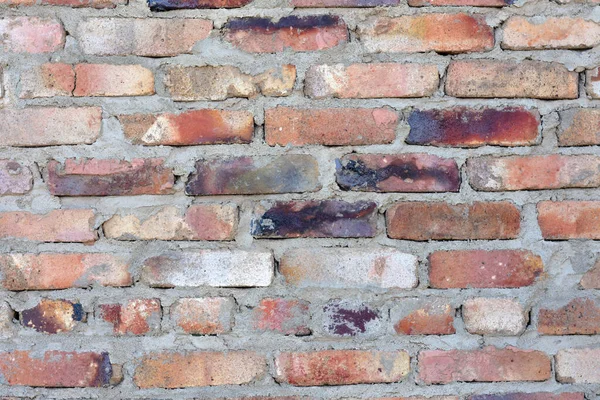 brick wall of bricks of different colors. red color prevails