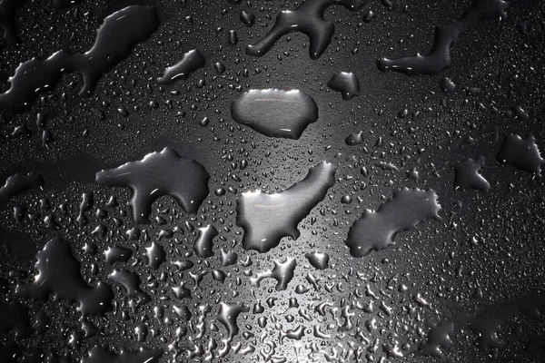 Large droplets of different sizes on a metal surface. — Stock Photo, Image
