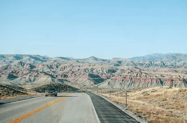 Un camino ancho con montañas rojas en el fondo — Foto de Stock