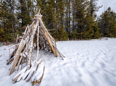 El yapımı Tee Pee Kışın karlı ve karanlık ormanlı