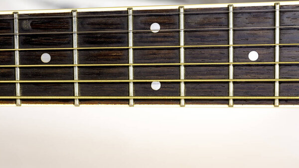 Close up of a guitar neck with frets