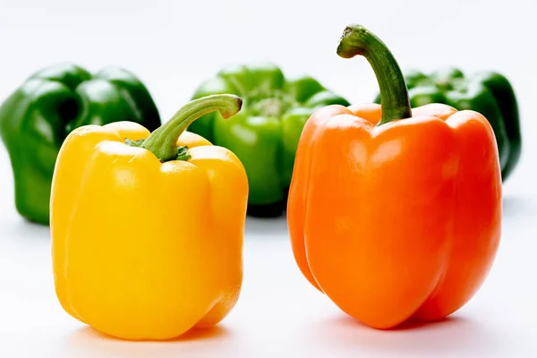 Pimientos anaranjados y amarillos con verdes en el fondo — Foto de Stock