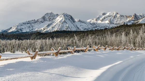 Kutub pagar tongkat di atas salju bersama dan jalan Idaho dengan mou — Stok Foto