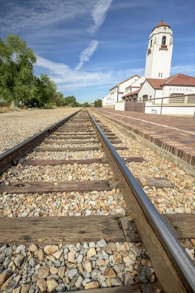 青い空と雲のある駅の前を通る鉄道線路 — ストック写真