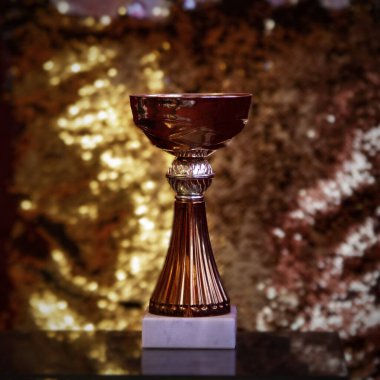 Altın arka planda ön görüşlü şampiyon kupa.