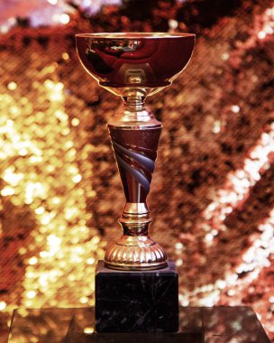Altın arka planda altın kupa kazandı.