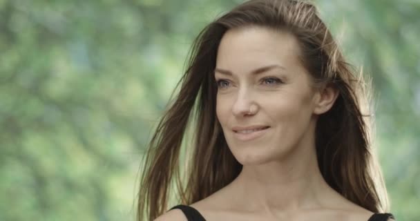 Close up of a beautiful caucasian woman relaxing in nature. slow motion medium shot in 4k — Stock Video